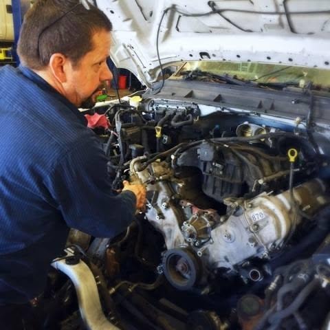 Mechanic inspecting a vehicle engine